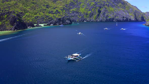 Aerial Drone View of White Traditional Filipino Boat Floating on Top of Clear Blue Water Surface. El