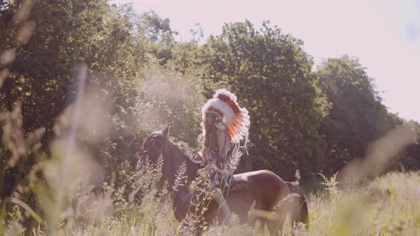 Girl In Native American Headdress On Horseback In Meadow