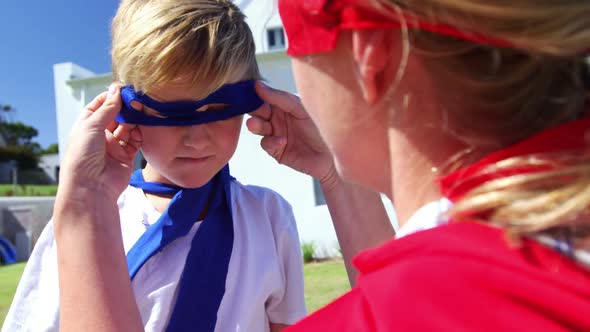 Mother adjusting mask of her son in garden 4k