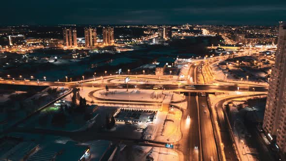 Night city time lapse; illuminated streets and moving cars in winter evening 