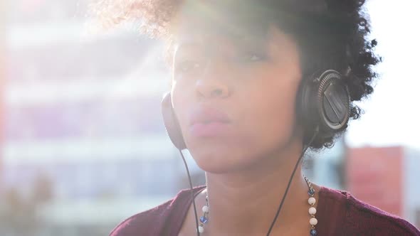 Young black woman listening music headphones serene