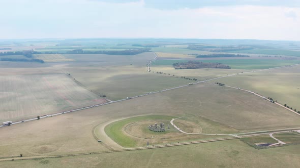 High circling drone shot of Stonehenge near A303 highway UK