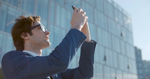 Young Businessman Using Smartphone While Standing Downtown