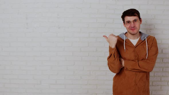 Shocked Man in Glasses Looking at Camera on White Brick Wall