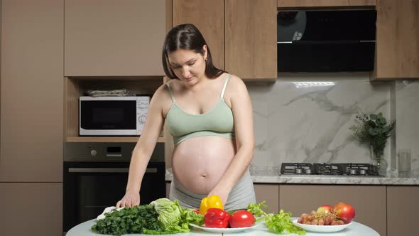 Pregnant Woman Strokes Belly Cutting and Eating Bell Pepper