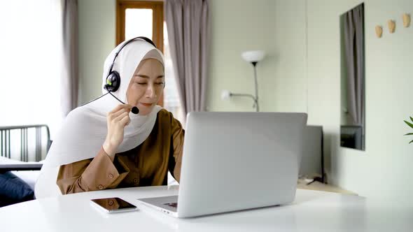 Portrait of muslim operator business woman working with headset and laptop computer