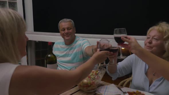 Family Clinking Glasses at Dinner Table