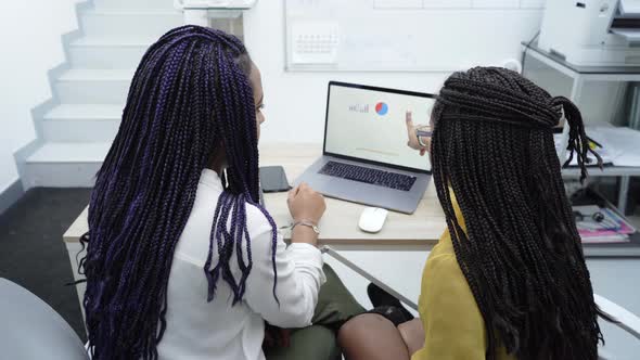 Two young black women working in the office.