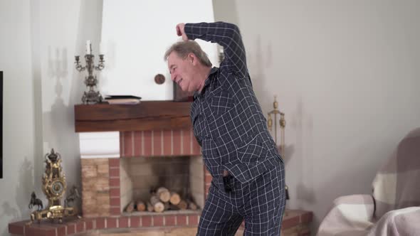 Positive Active Caucasian Retiree Doing Morning Exercises at Home, Portrait of Senior Old Man Go in