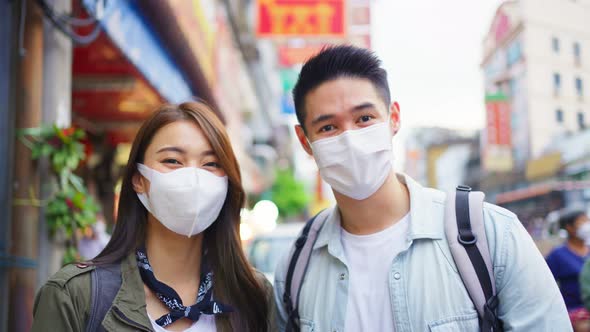 Portrait of Asian couple wear mask, travel in city for honeymoon trip.