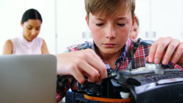 Schoolboy repairing a printer in the classroom