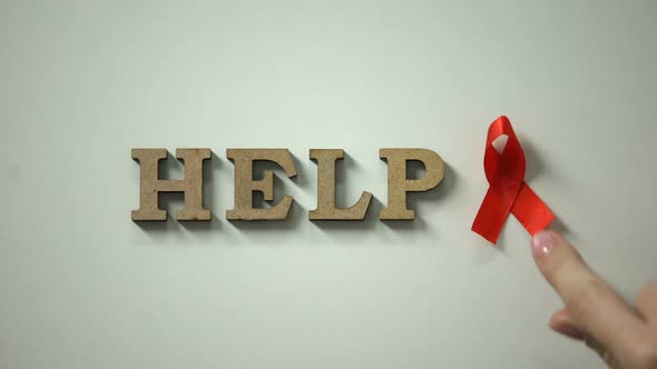 Help Word and Red Ribbon on Table, AIDS Awareness, Safe Sex and Protection