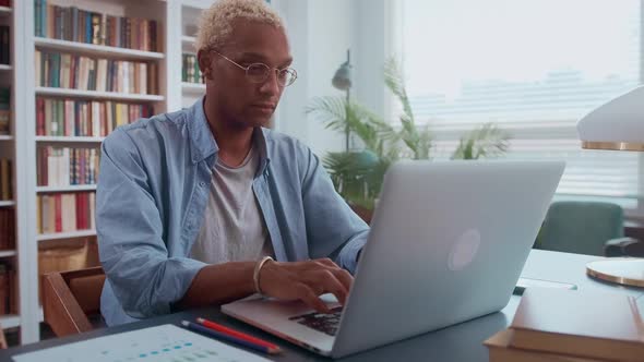 African American Business Man Working on Laptop with Electronic Documents