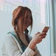 Woman with red hair and freckles smiling while using a smartphone - VideoHive Item for Sale