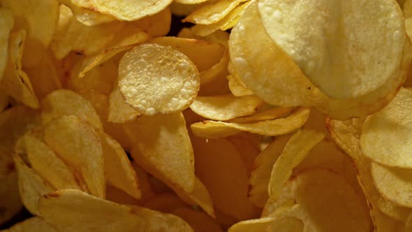 Super Slow Motion Shot of Potato Chips Flies After Being Exploded Against Black Background, 1000Fps.