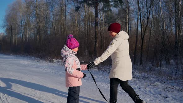 Two females persons sledding and having fun outside