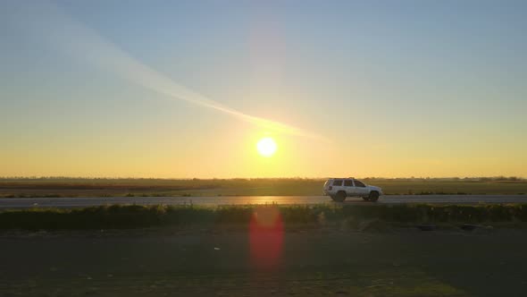 Aerial View of Intercity Road with Fast Driving Car at Sunset