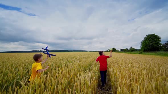 Boys running with plane toy. Boys running with toy plane on golden wheat field
