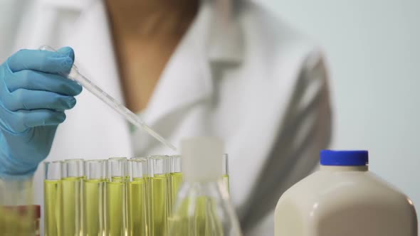 Laboratory Assistant Checking Biological Material on Viruses Using Pipette