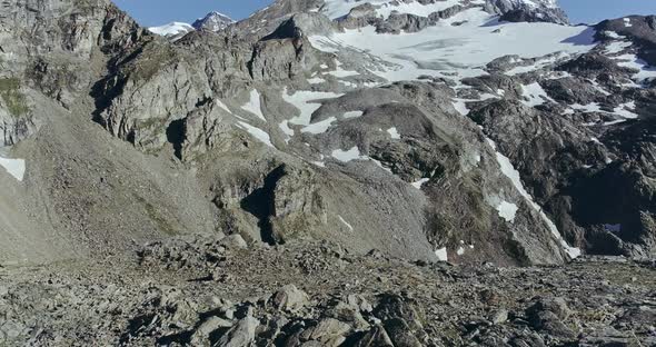 View of Rocky and Snowy Mountain Peak Rocks on the Floor and Blue Sky at the Back of Mountain Range