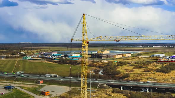 Crane Operates on Construction Site Under Cloudy Sky