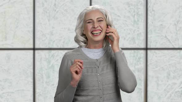 Cheerful Senior Woman Talking on Transparent Phone