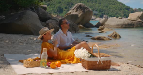 Couple of Young People Resting on the Secluded Beach Having Picnic Rest and Enjoy at Summer Time