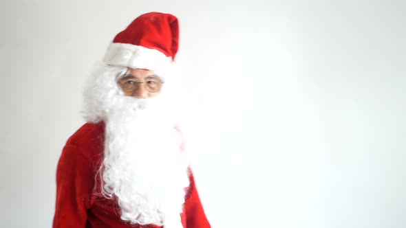 Cheerful funny Santa Claus touching beard looking at camera