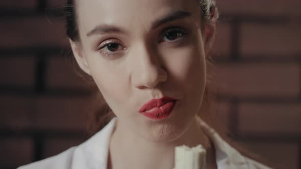 Beautiful Woman Face Eating Banana Looking Into Camera