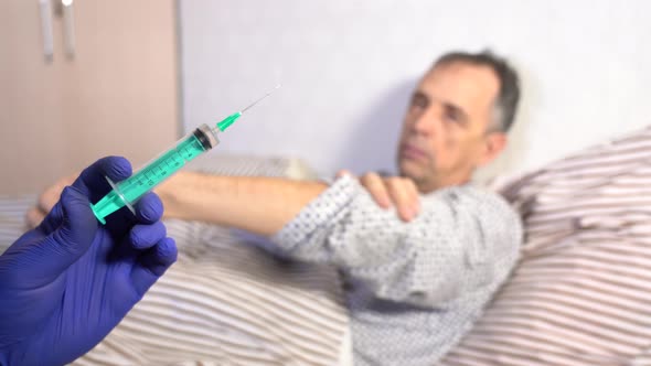 Syringe with Medicine on the Background of a Sick Senior