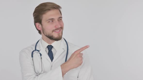 Young Doctor Pointing on Side on White Background