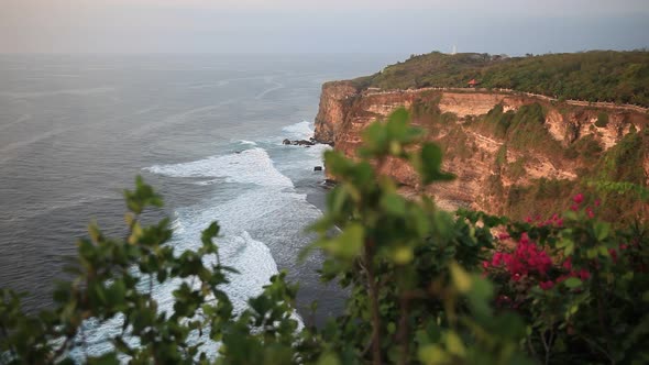 Sunset in Uluwatu Coastline in Bali Indonesia with Beautiful Rocky Cliffs and Wavy Sea