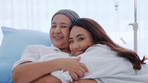 Young daughter encourages and comforts a mother with cancer during hospitalization.