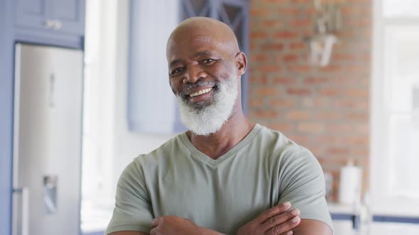 Portrait of african american senior man with arms crossed smiling at home