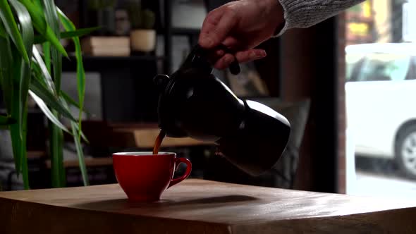 Cinematic Slow Motion Pouring Coffee in Red Cup from Black Mokapot
