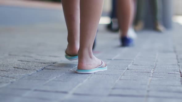 Feet of diverse schoolchildren standing in queue to get temperature measured