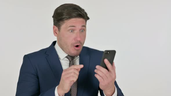 Middle Aged Businessman Reacting to Loss on Smartphone, White Background