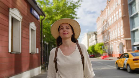 Smiling young girl walking down the street in the city in summer