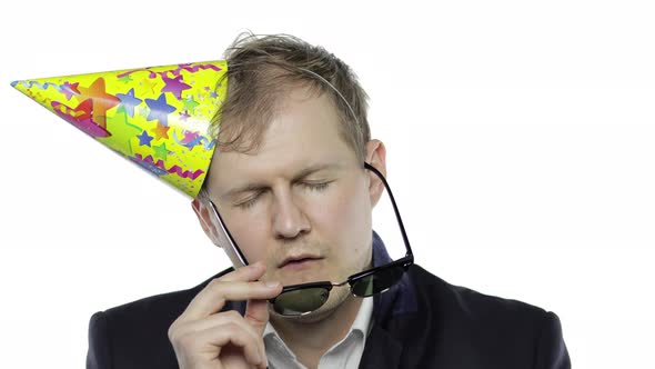 Drunk Sleepy Young Businessman with Hangover in Festive Cap and Sunglasses