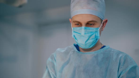 Surgeon operating live shot. Handsome middle aged doctor in modern operating room