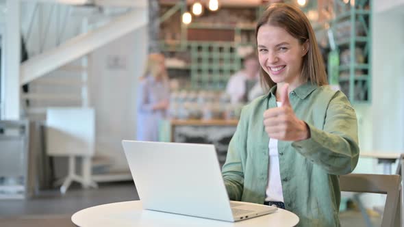 Appreciative Woman with Laptop Doing Thumbs Up