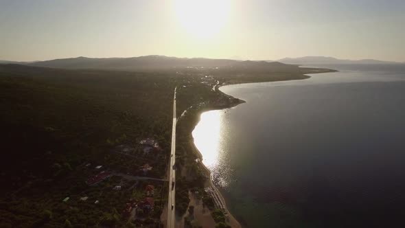 Flying Over Sea and Coast with Road Along Waterfront. Trikorfo Beach, Greece