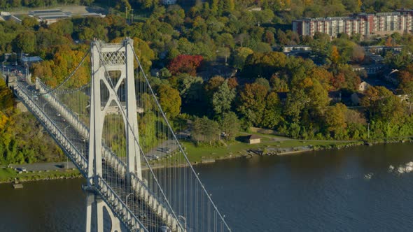 Aerial of Mid-Hudson Bridge and town amidst autumn trees at distance