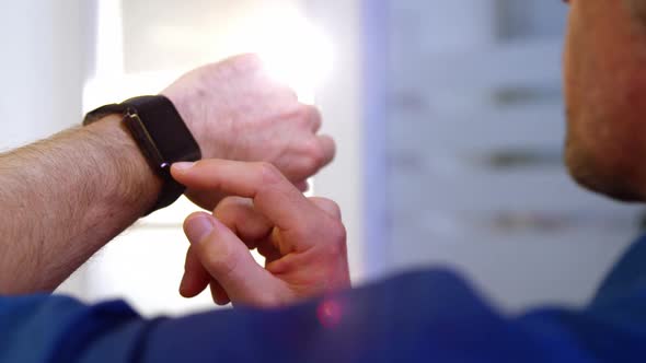 Close-up of male business executive using smart watch