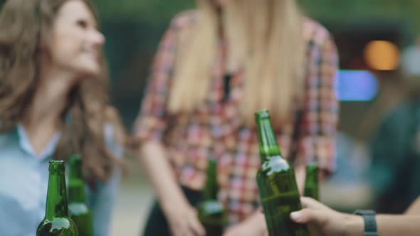 Friends Drinking Beer And Toasting At Outdoor Party