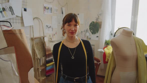 Portrait of Positive Female Dressmaker in Sewing Workshop