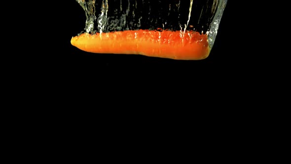 Super Slow Motion One Fresh Carrot Falls Under the Water with Air Bubbles