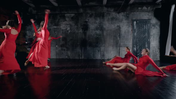 Teenage Girls Are Performing Dance in a Rehearsal Room, Wearing Red Dresses, Leaping and Whirling