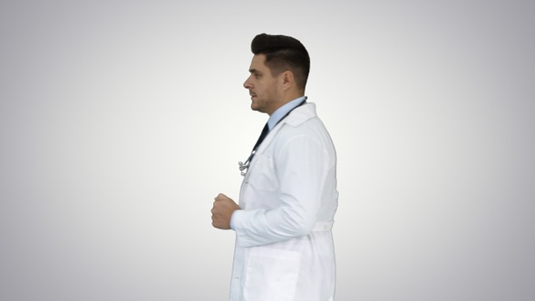 Walking male doctor passing by on gradient background