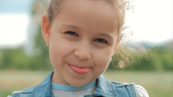 Close Up Portrait Cute Happy Caucasian Little Girl Smiling Looking the Camera, Enjoying Warm Summer